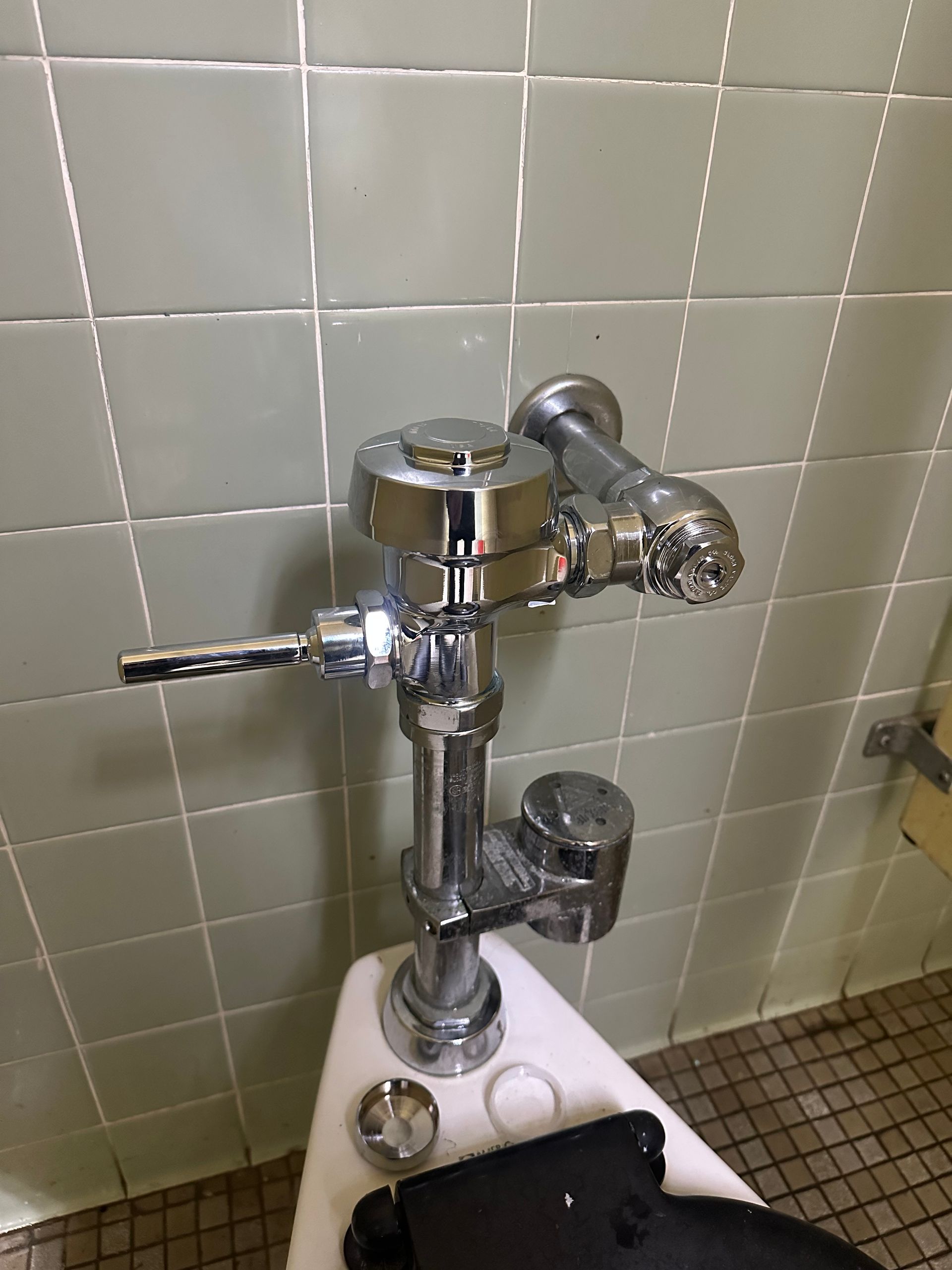 Toilet and plumbing tools on bathroom floor.