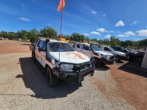 White Work Trucks Parked on A Gravel Lot Under a Blue Sky โ Projected Contracting Electrical Services In Portsmith, QLD