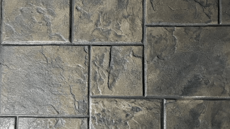 Gray and tan stone paver pattern with rectangular blocks and textured surfaces