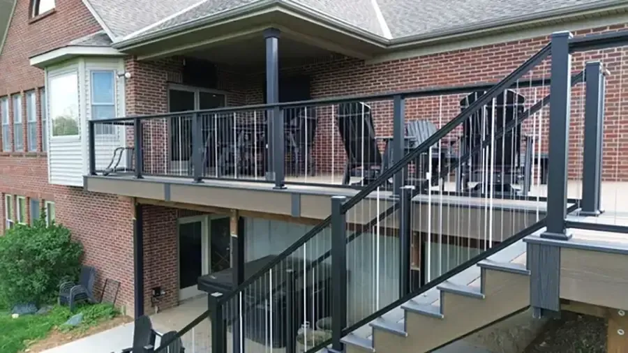 Brick apartment building with covered balcony and black metal staircase leading to an upper deck