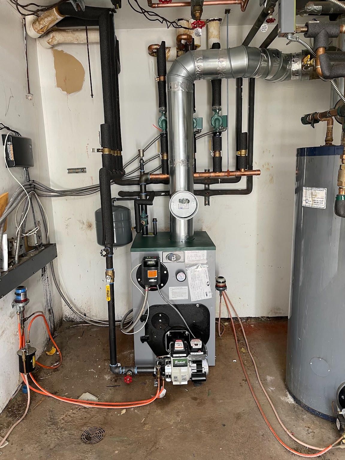 Technician adjusting a valve on a water heater with pressure gauge in a utility room