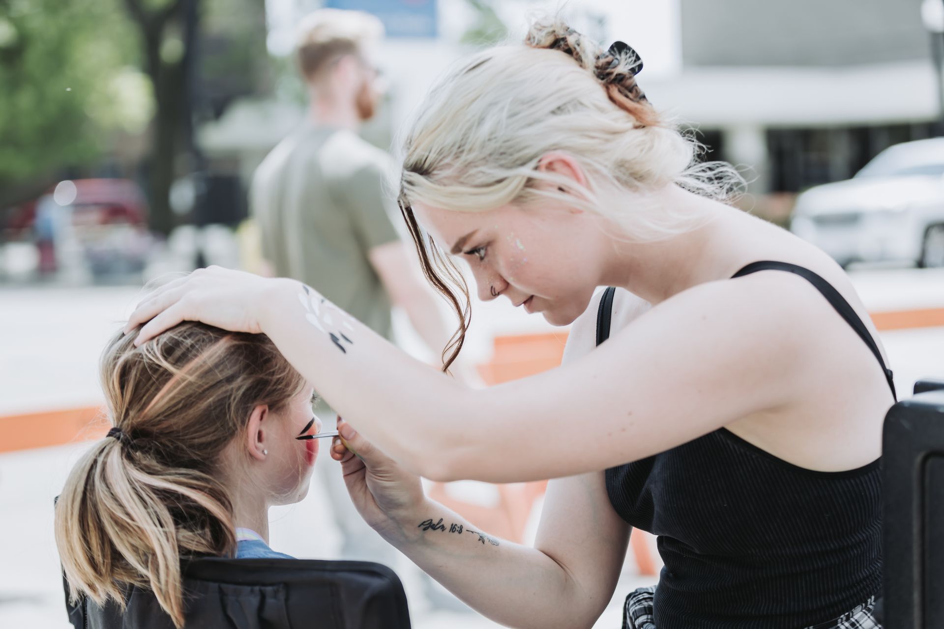 A woman is applying makeup to another woman 's face.