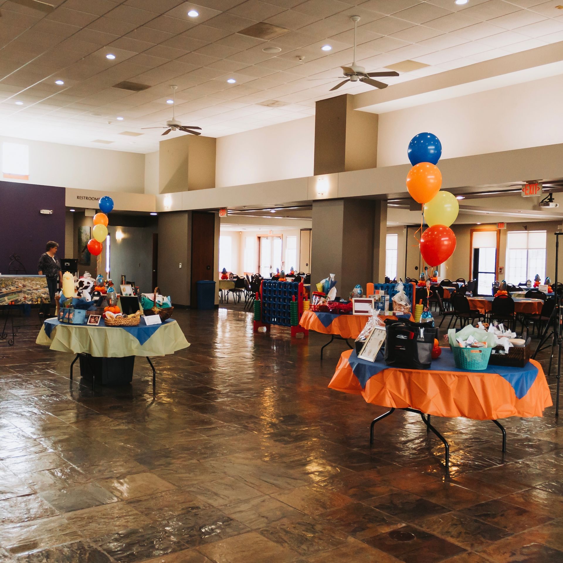 A large room with tables and balloons in it