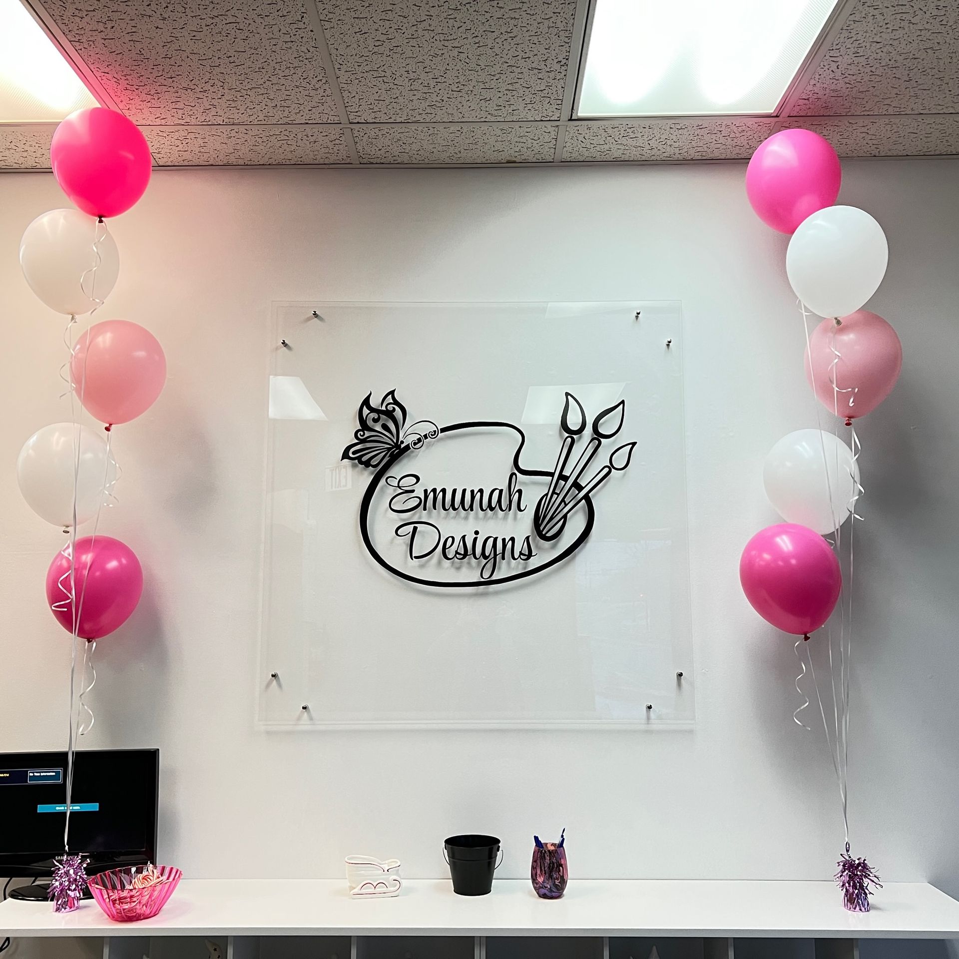 Balloons are hanging from the ceiling in front of a sign that says savannah designs