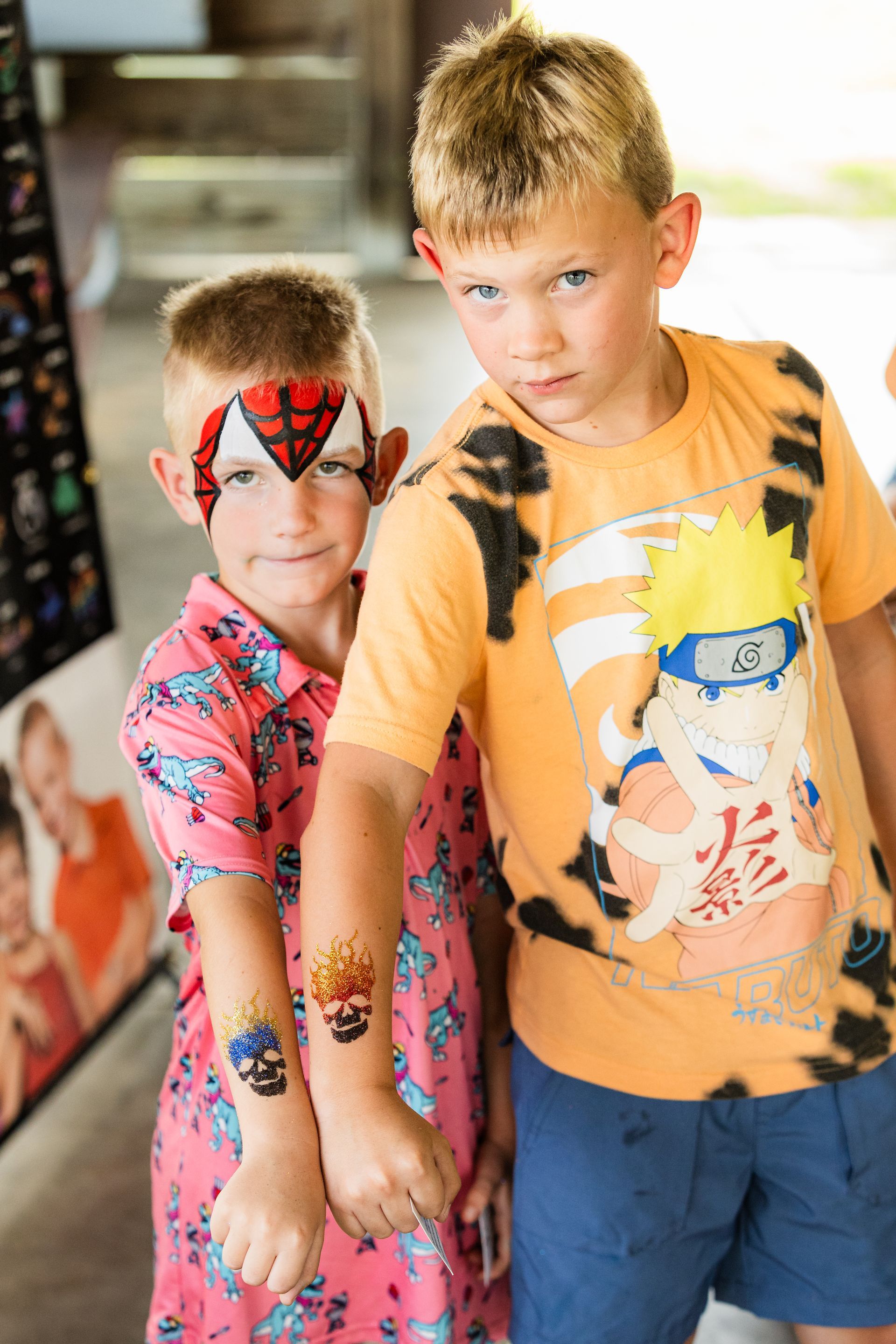 Two young boys are standing next to each other with their faces painted.