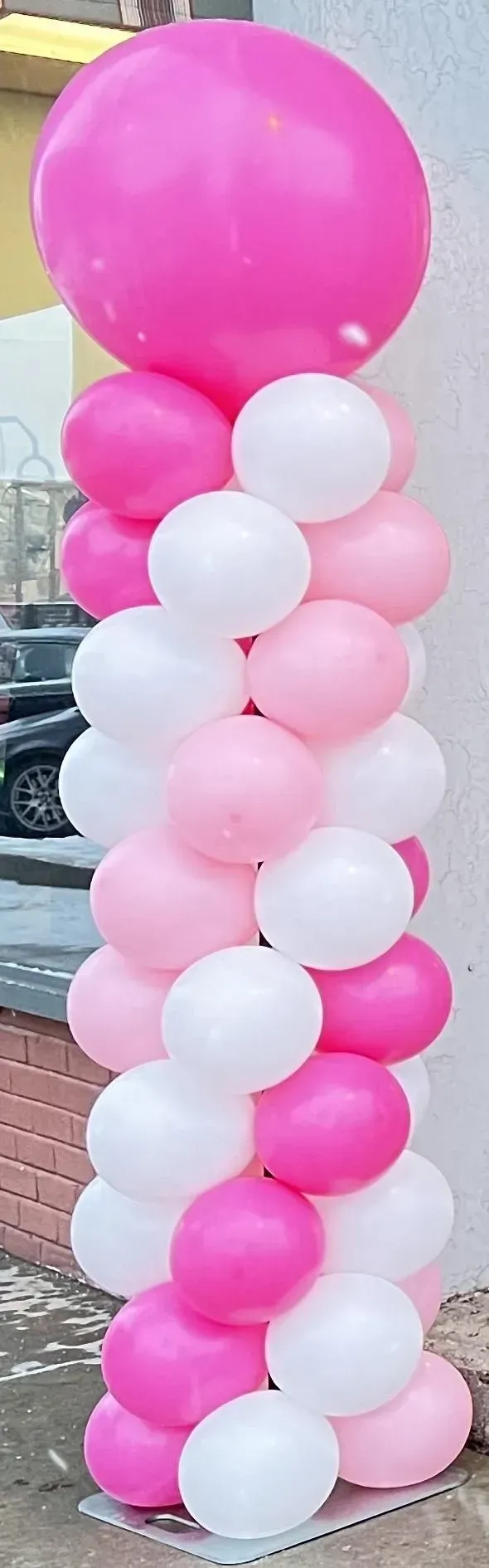 A stack of pink and white balloons sitting on top of each other.