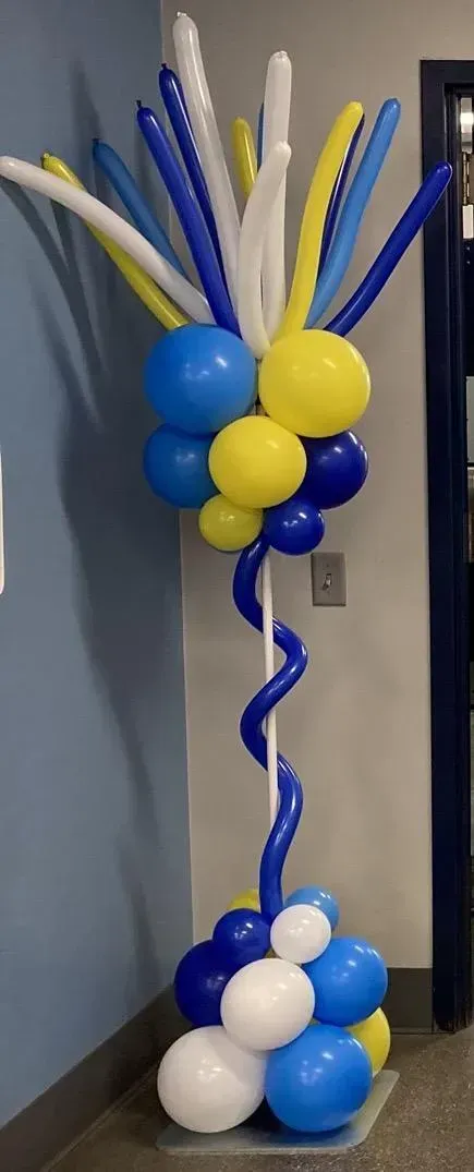 A bunch of blue and yellow balloons are sitting on top of a table.