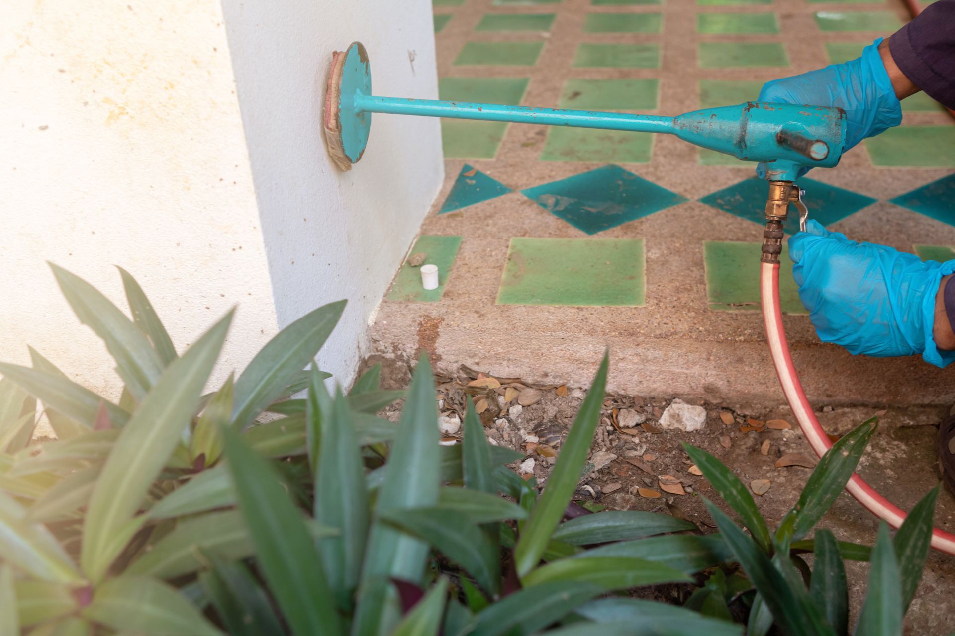 A person is spraying a hose on a wall.