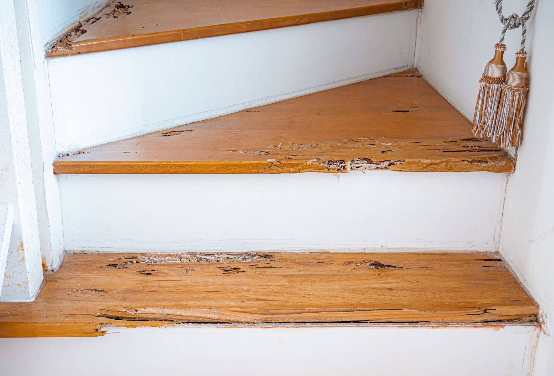 A close up of a wooden staircase with peeling paint.