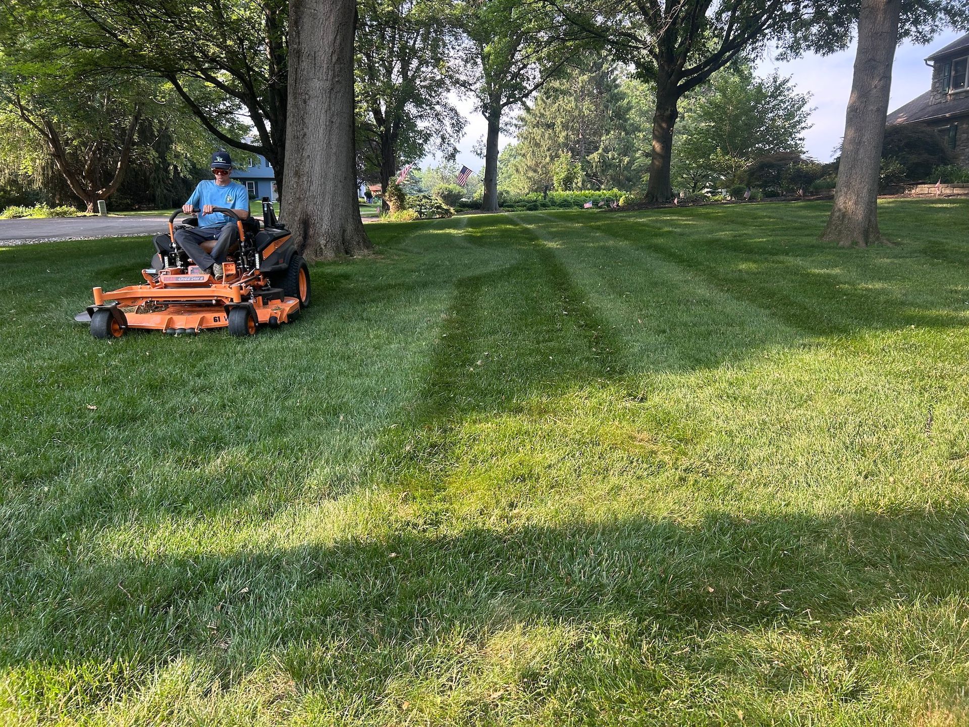A man is riding a lawn mower in a park.