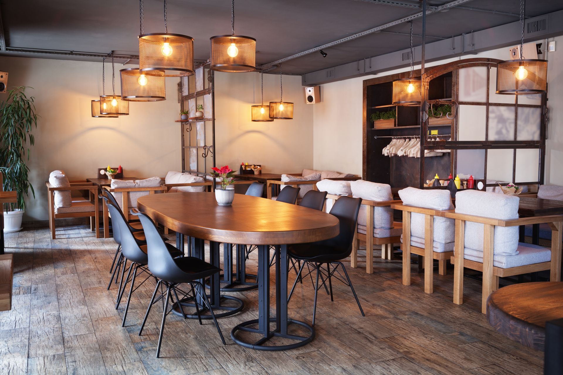 Restaurant interior with wooden tables, chairs, and hanging lights.
