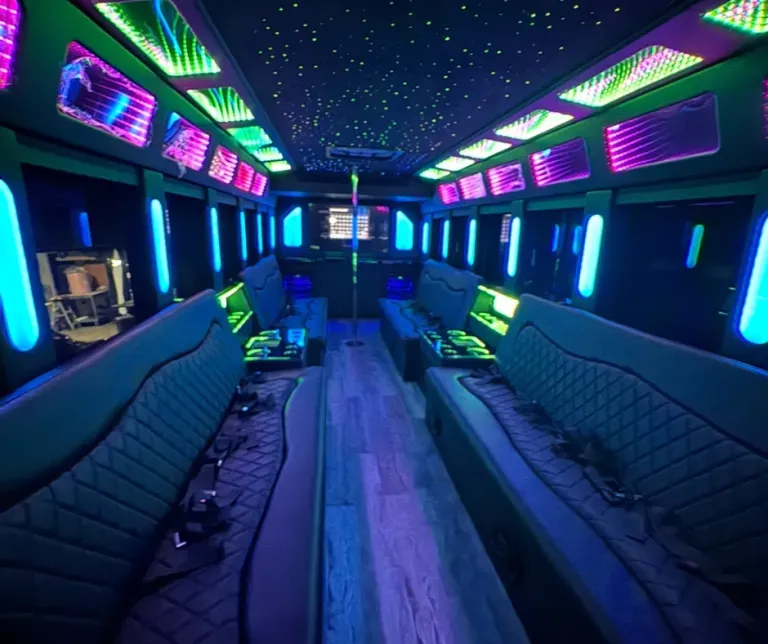 Neon-lit party bus interior with blue seats, glowing ceiling panels, and purple-green lights