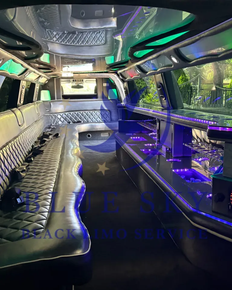 Luxurious limousine interior with silver seating, neon lighting, and mirrored ceiling panels