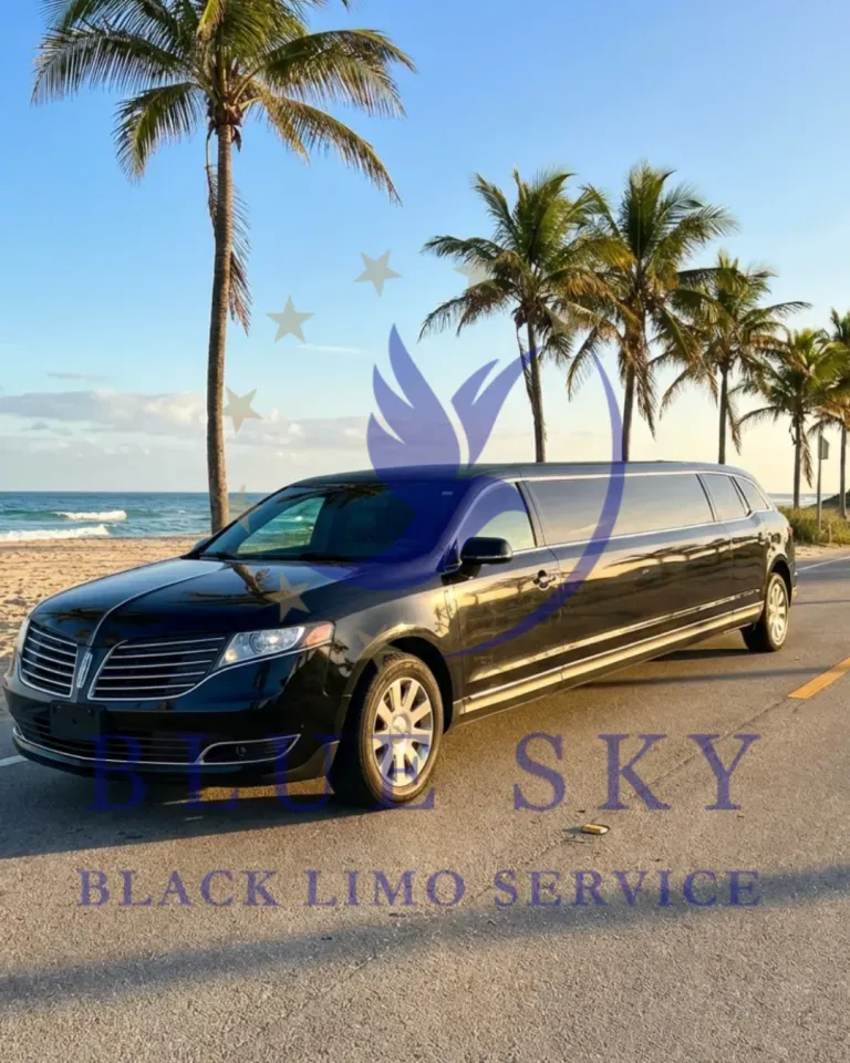 White stretch limousine parked on a sunny palm-lined street with blue glass buildings in the background