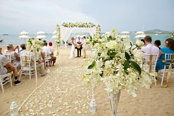 A wedding ceremony is taking place on the beach.