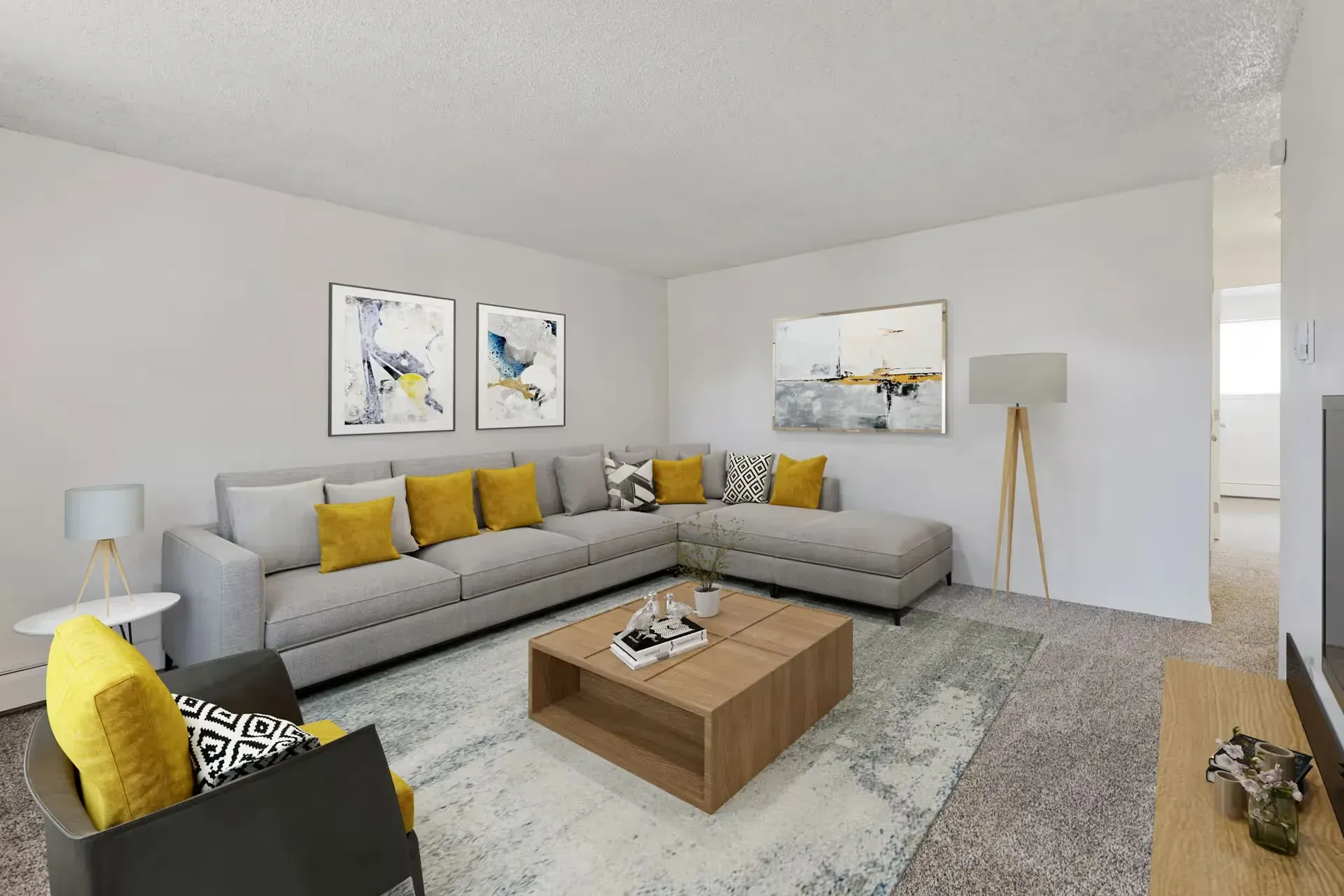 Modern living room in an apartment with a gray sectional sofa, yellow throw pillows, and abstract art at Avec Greeley.