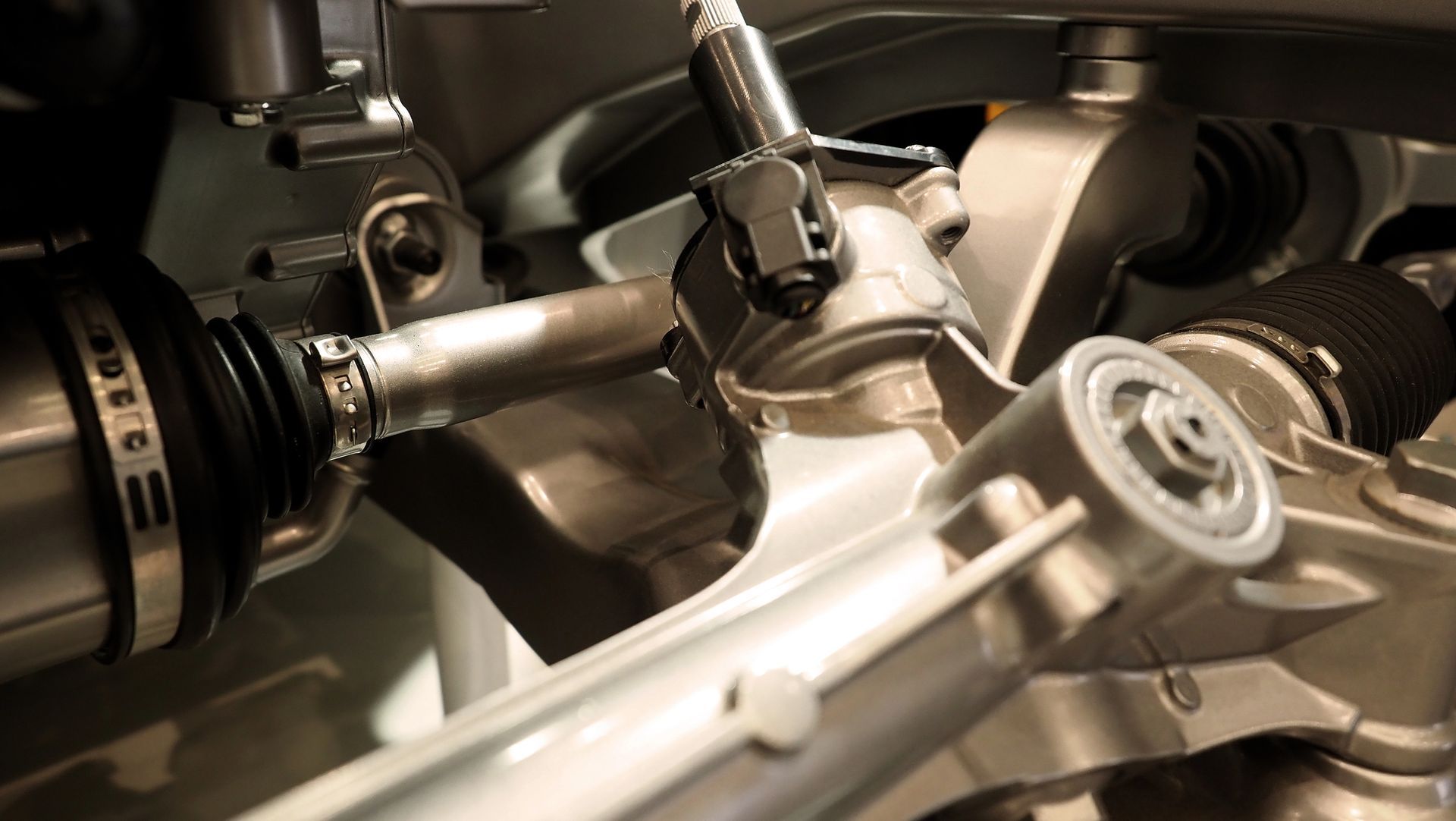 Primo piano dei componenti delle sospensioni dell'auto: assi, giunti e altre parti metalliche.