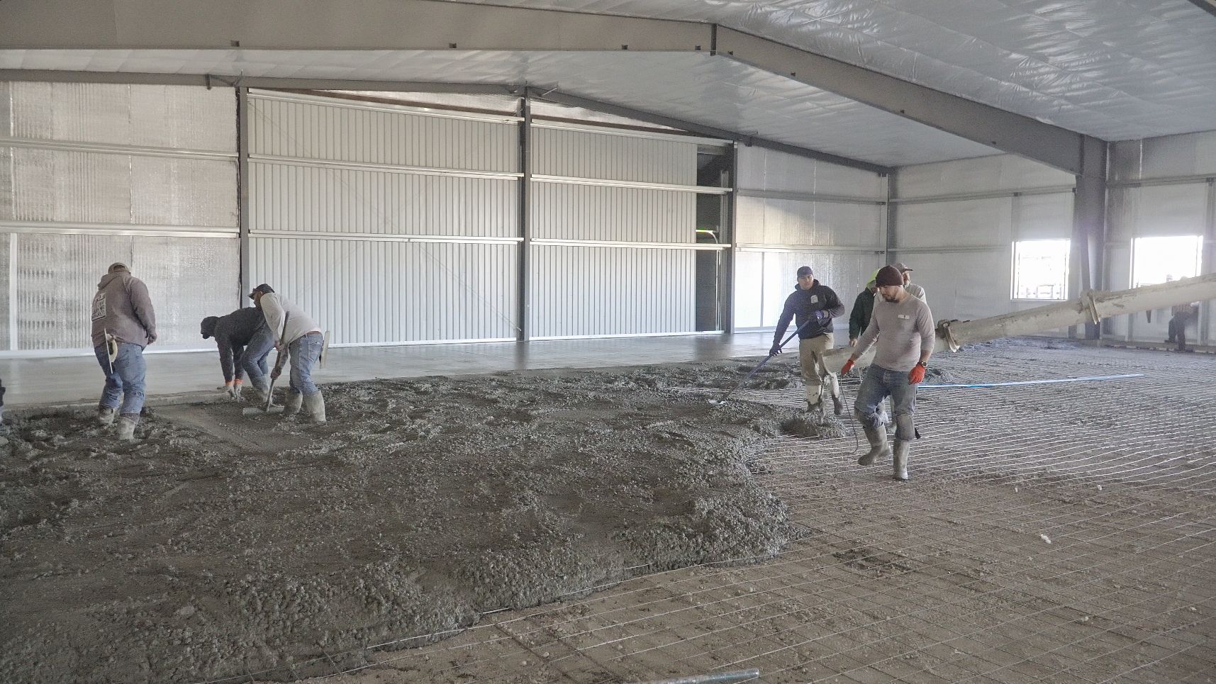 A group of construction workers are pouring concrete into a building.