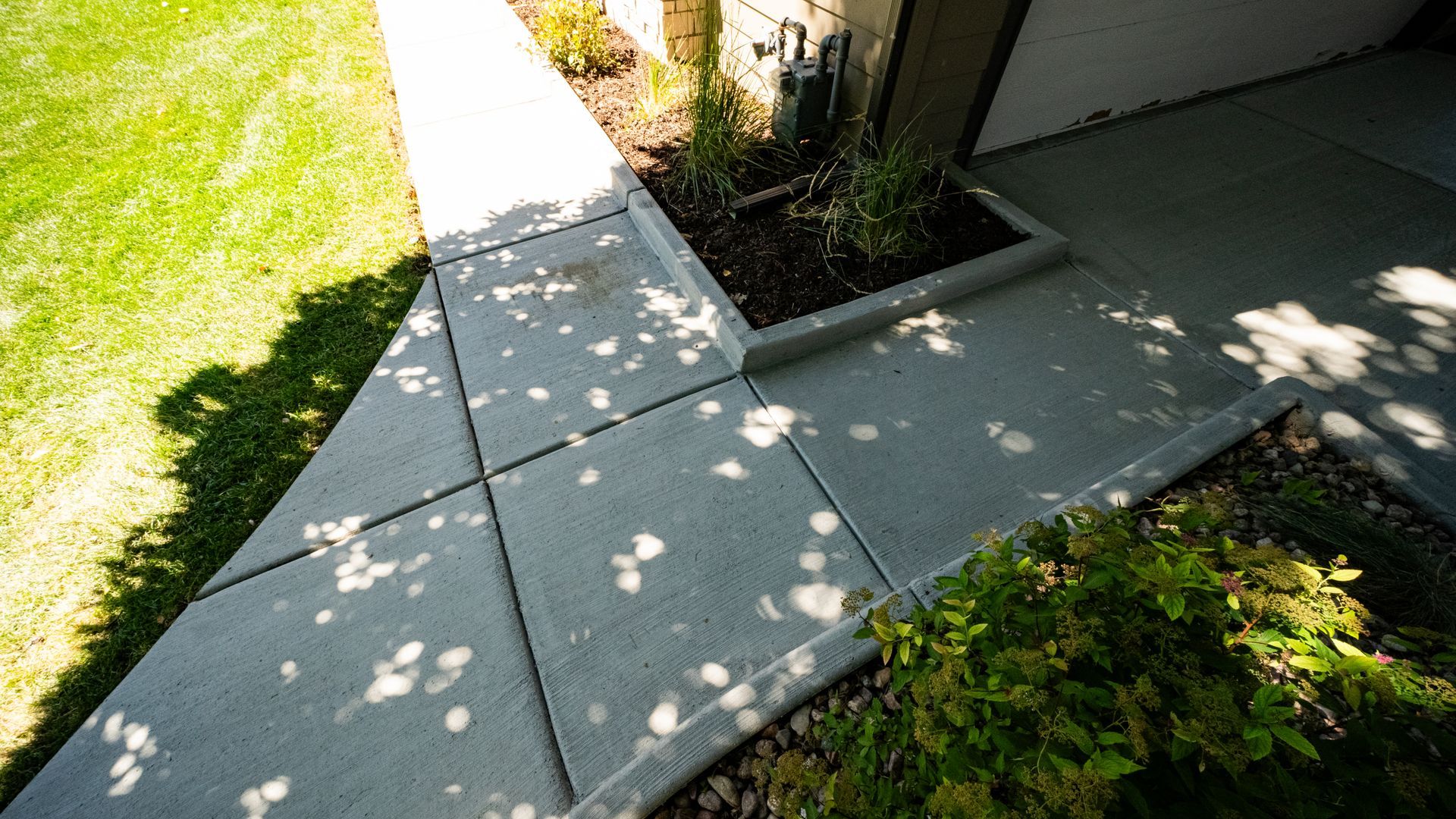 A man is spreading concrete on a sidewalk near a pool