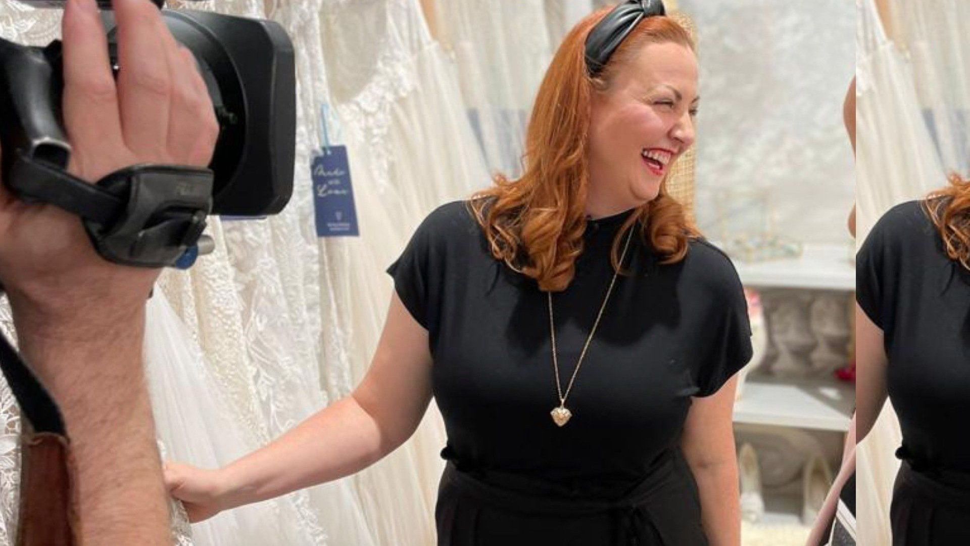 Eine Frau in einem schwarzen Kleid wird von einem Kameramann gefilmt.