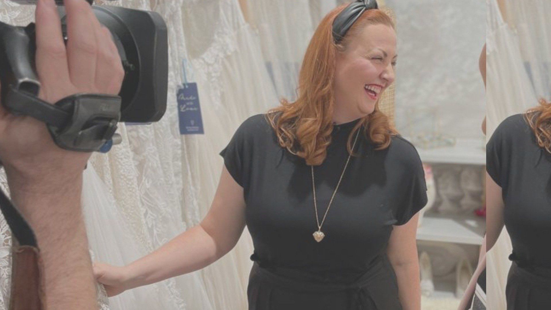Eine Frau in einem schwarzen Kleid wird von einer Kamera gefilmt.