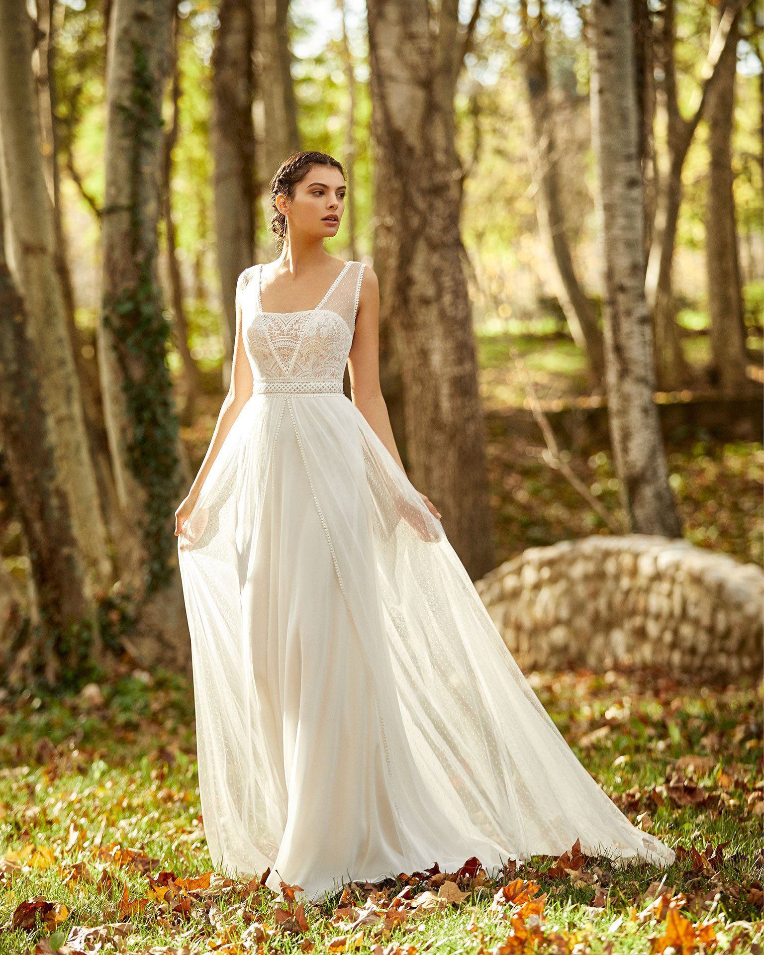 Eine Frau in einem weißen Brautkleid steht mitten in einem Wald.