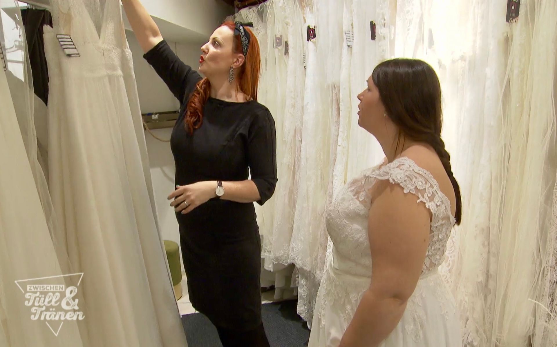 Zwei Frauen schauen sich in einem Geschäft Brautkleider an.