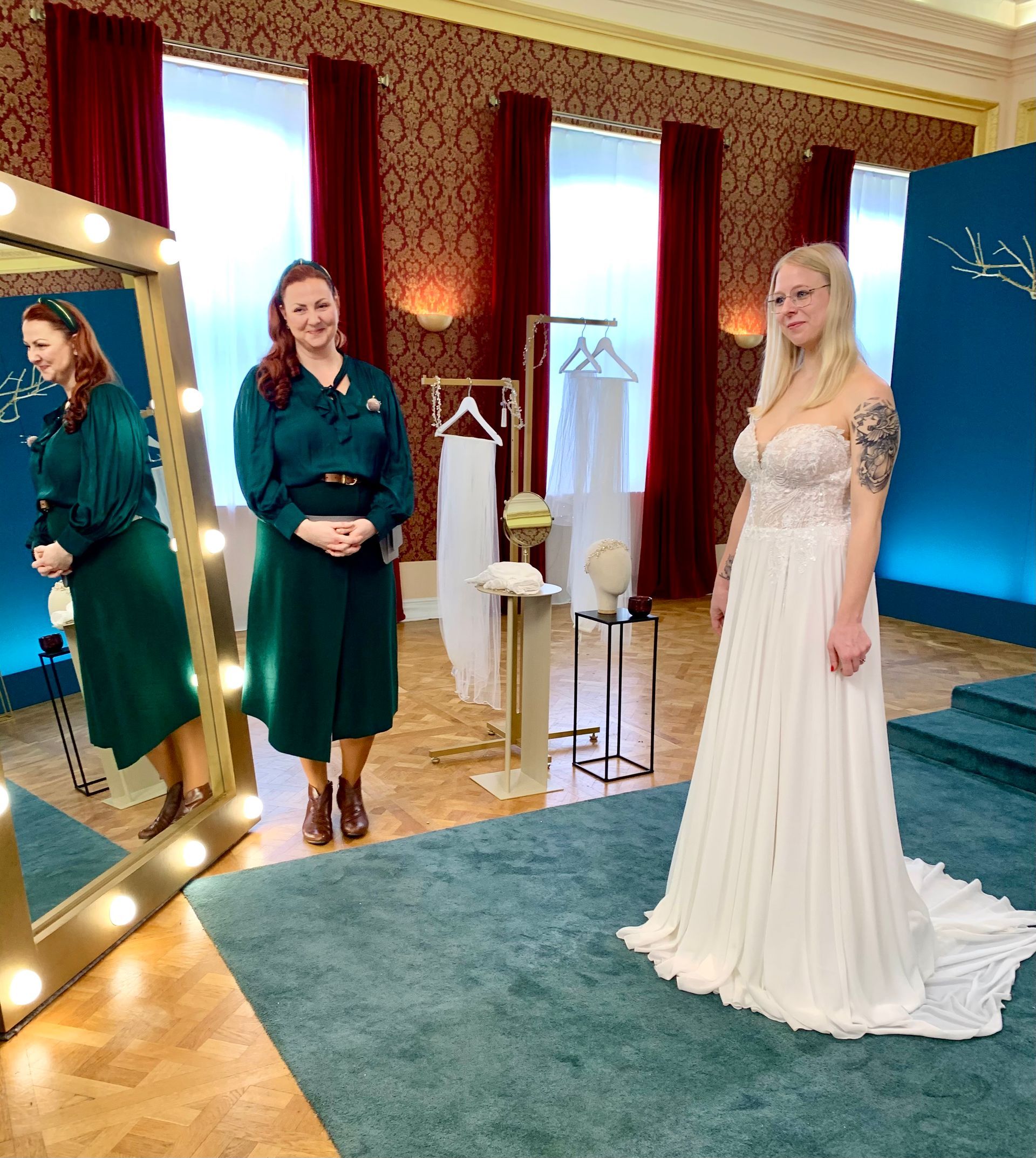 Eine Frau in einem Brautkleid steht in einem Zimmer vor einem Spiegel.