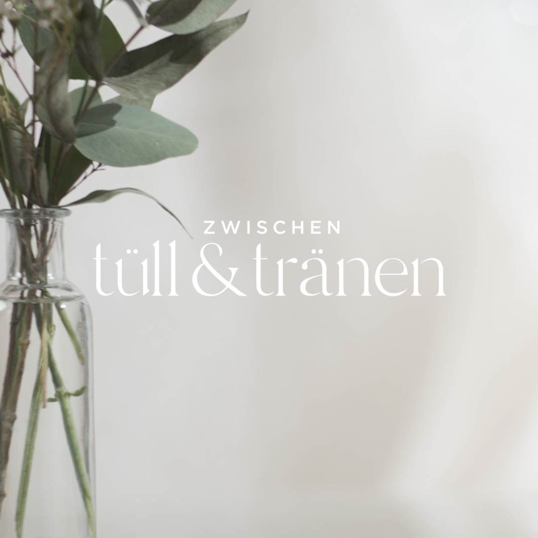 Eine Vase mit Blumen und den Worten „til & tränen“ auf dem Boden