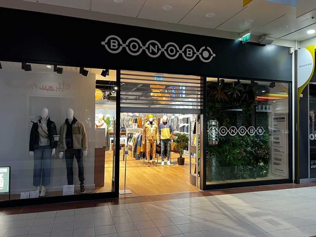 A store with mannequins in front of it in a mall.