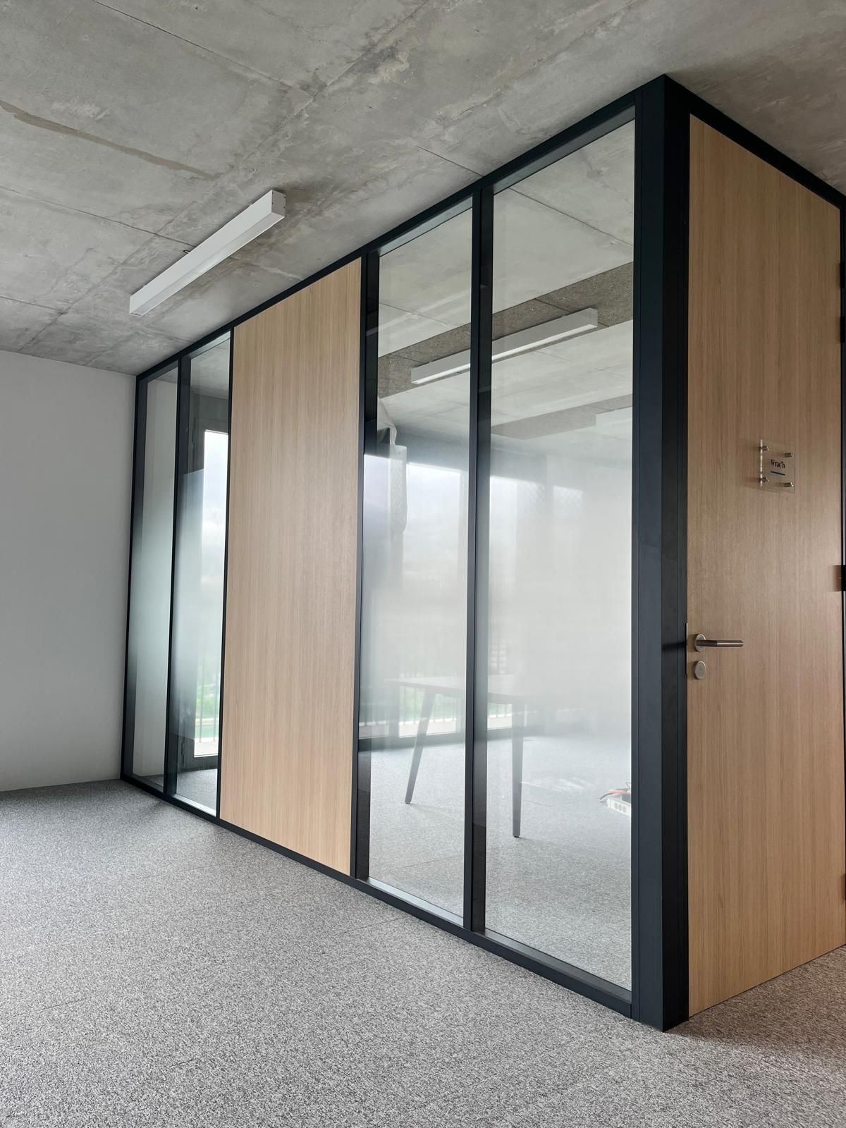 A room with a glass wall and a wooden door.