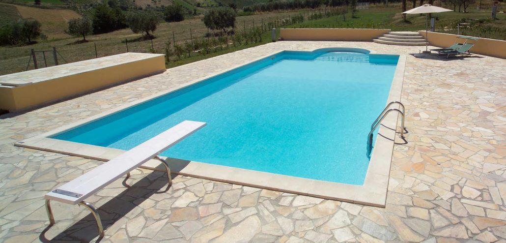 Una grande piscina con trampolino al centro