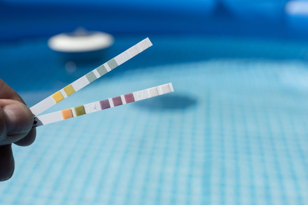 Hand With Measuring Strips To Control Water Quality In Pool — Beaches Pool Supplies in Kewarra Beach, QLD