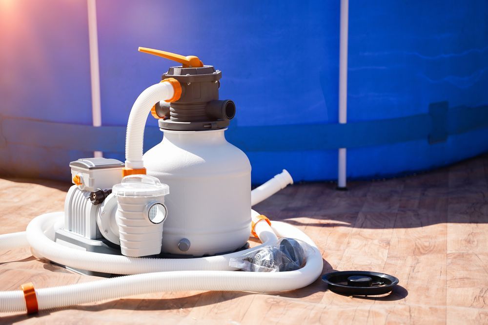 A Sand Filter Is Sitting on The Ground Next to A Swimming Pool — Beaches Pool Supplies in Kewarra Beach, QLD