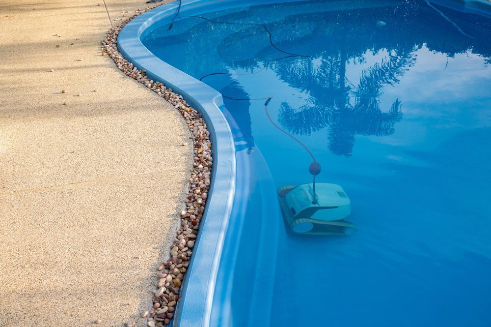 Pool cleaner is sitting in the middle of a swimming pool — Pool Equipment Installation in Kewarra Beach QLD
