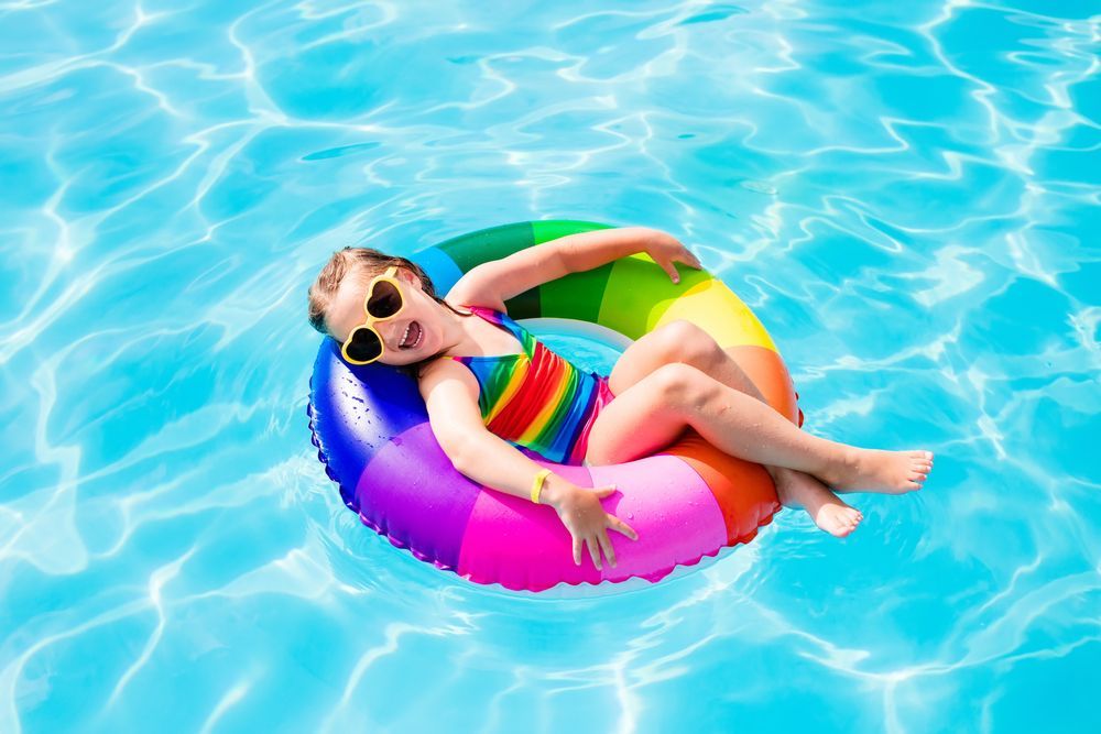 Happy Little Girl With Colourful Inflatable Ring — Beaches Pool Supplies in Kewarra Beach, QLD