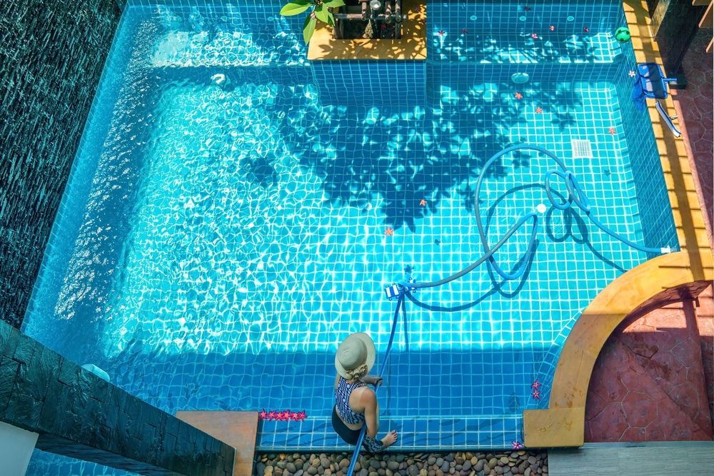 Woman Cleaning The Swimming Pool — Beaches Pool Supplies in Kewarra Beach, QLD