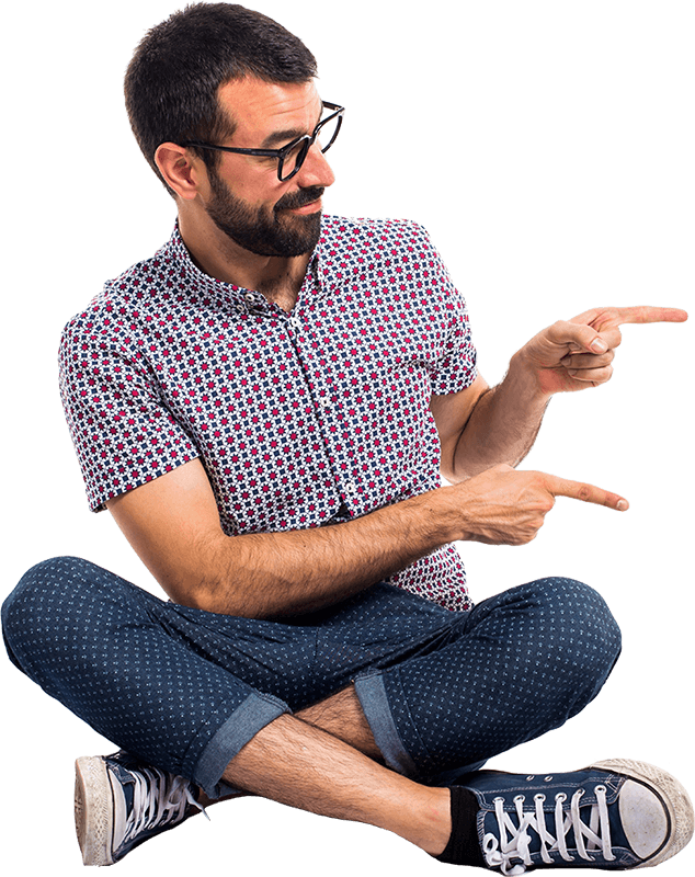 A man is sitting on the floor with his legs crossed and pointing at something.