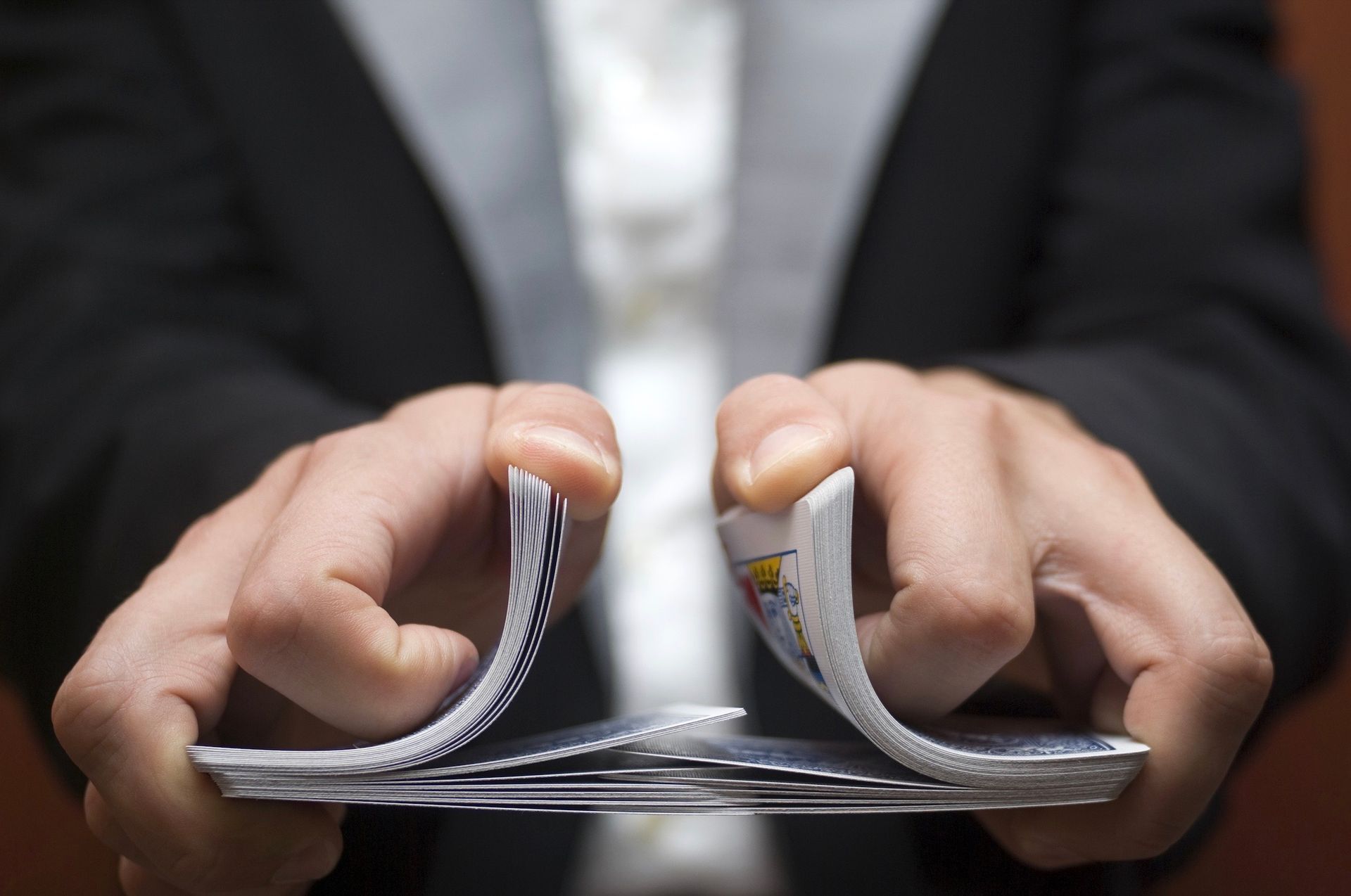 A person is holding a stack of playing cards in their hands