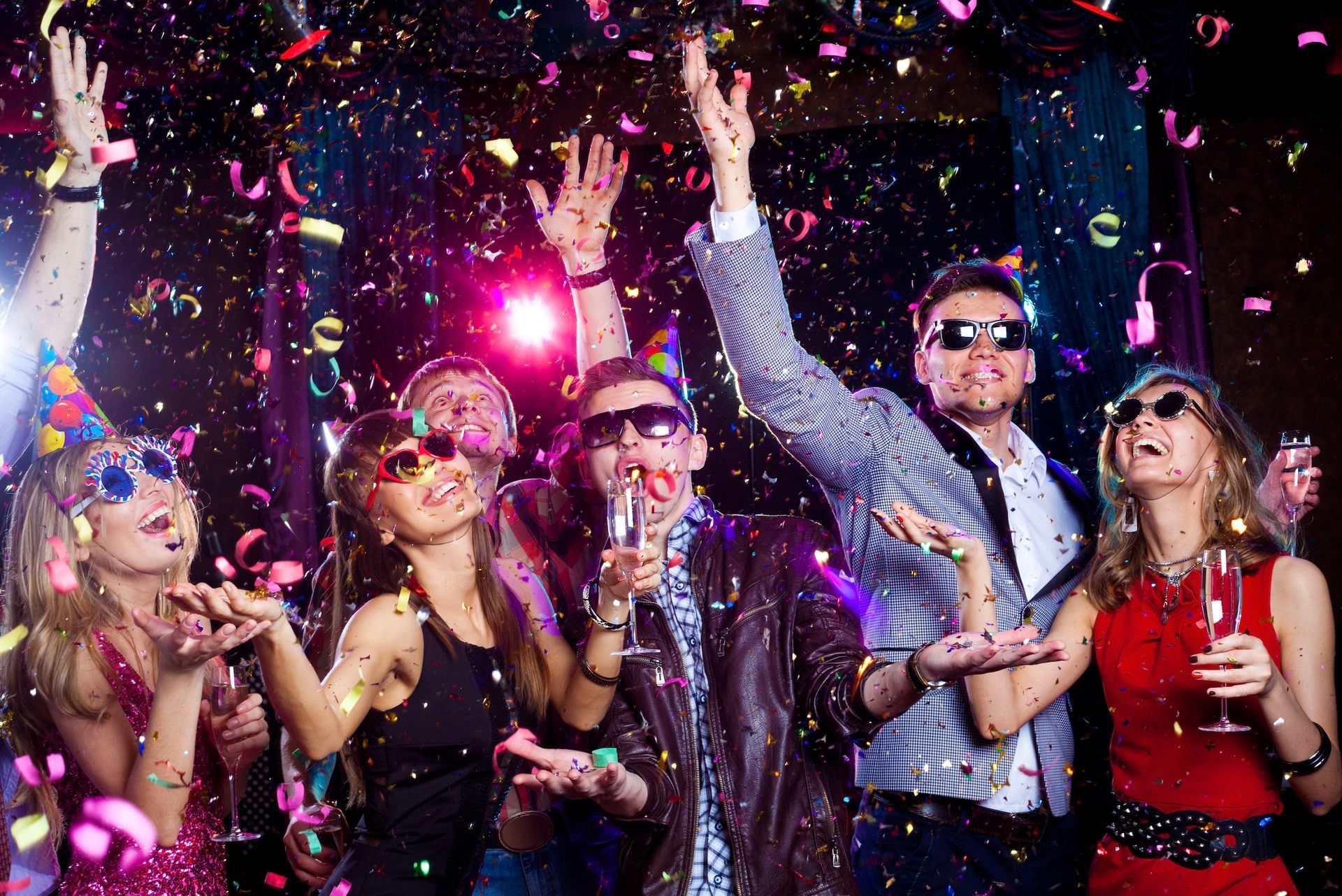 A group of people are having a party and throwing confetti in the air