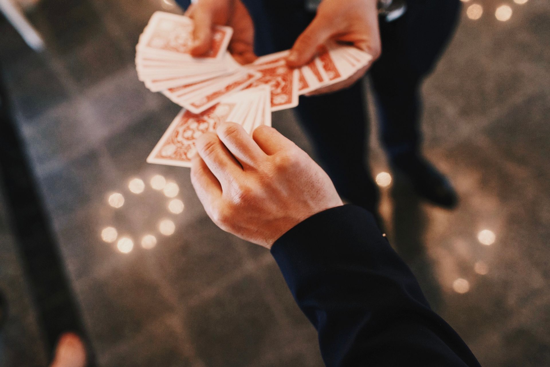 A person is holding a stack of playing cards in their hands.