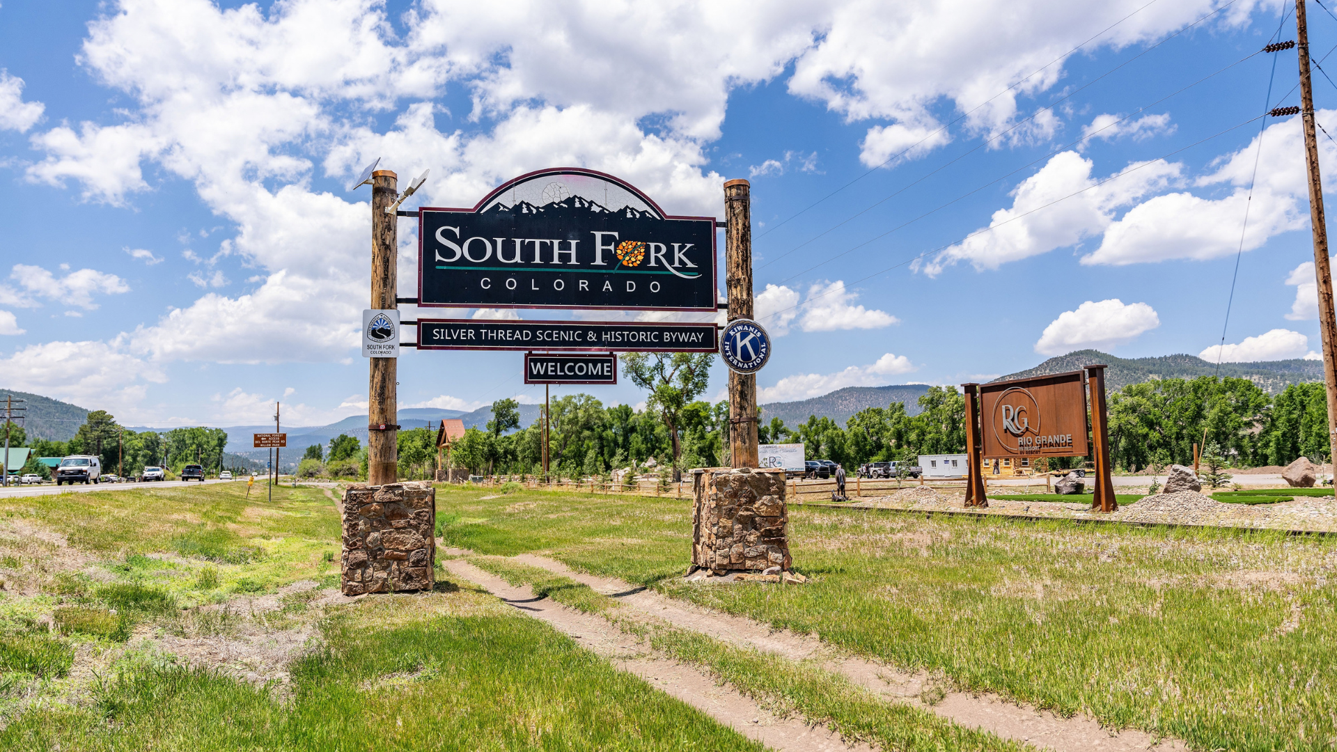 South Fork entrance sign in a grassy field under a bright blue sky with clouds at Rio Grande RV Resort