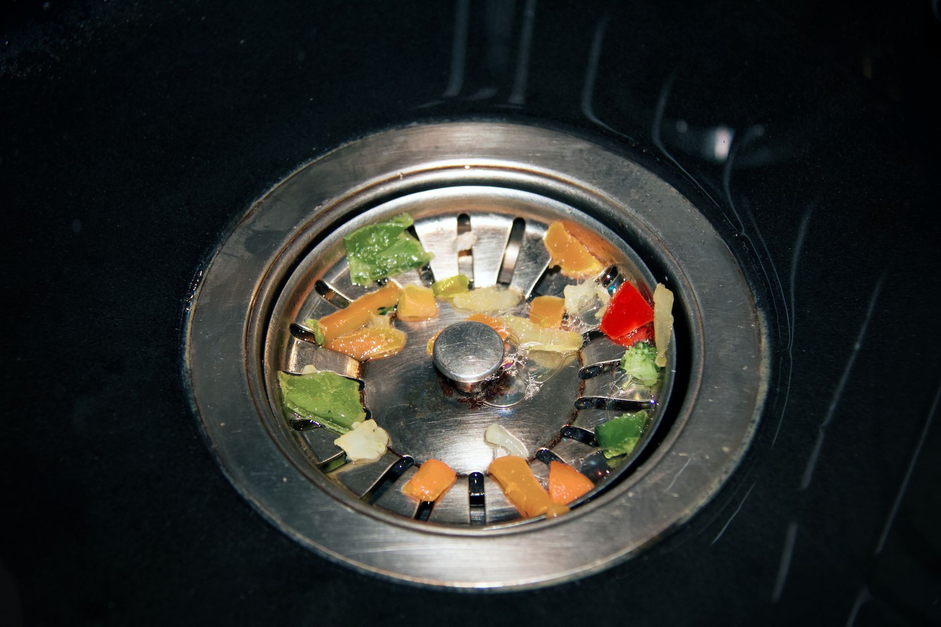 A sink drain with vegetables coming out of it A sink drain with vegetables coming out of it