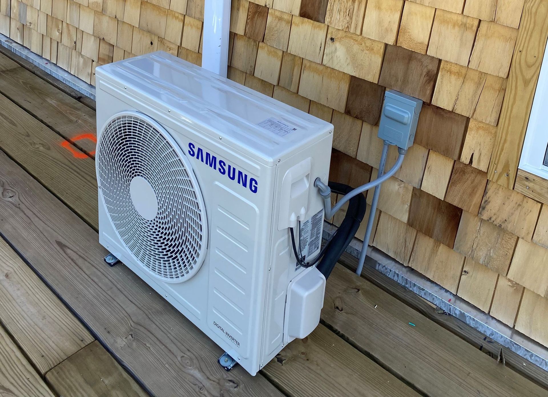 A man is working on an air conditioner with a tape measure A man is working on an air conditioner with a tape measure