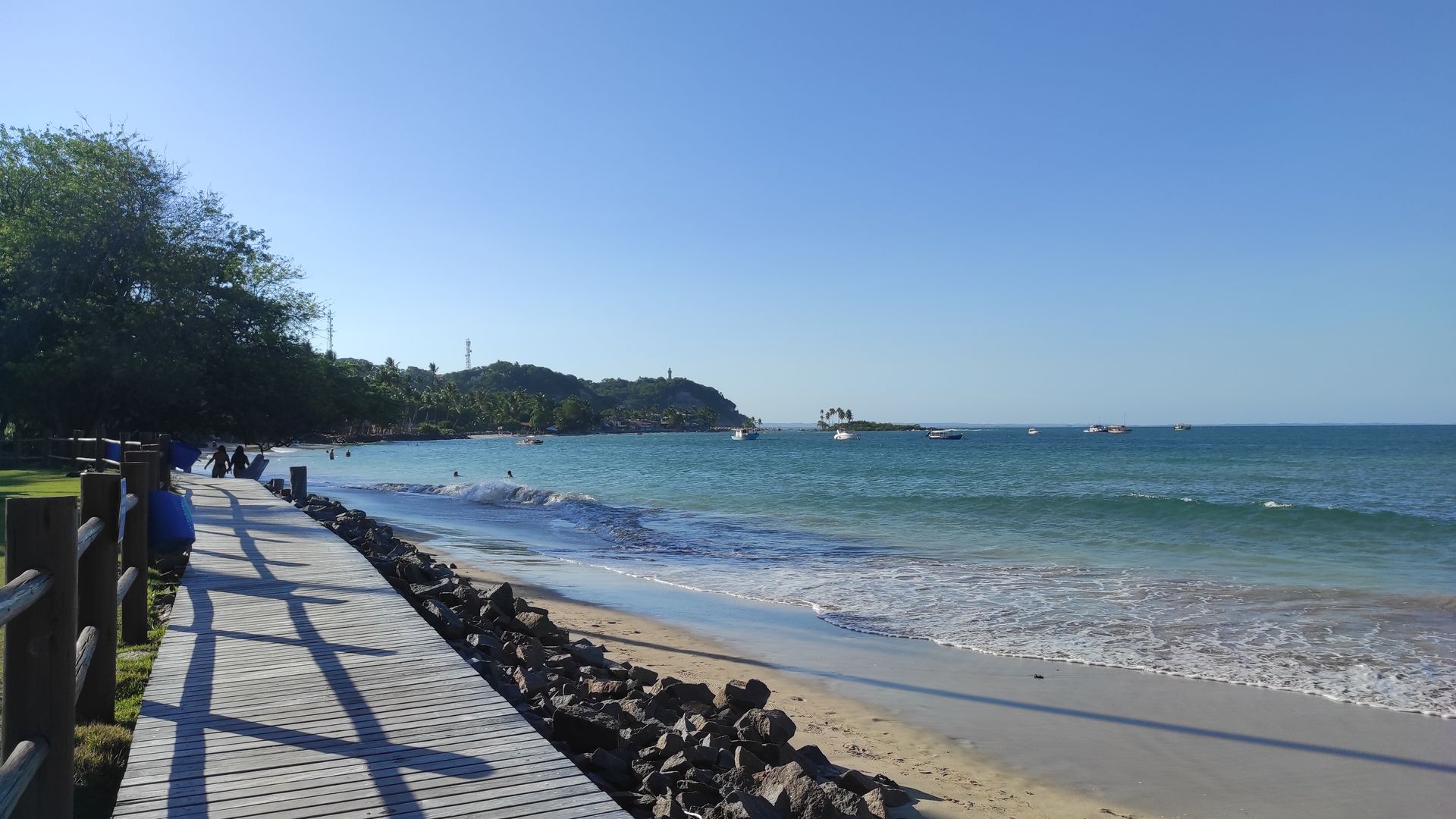 a beach with a wooden walkway leading to the ocean