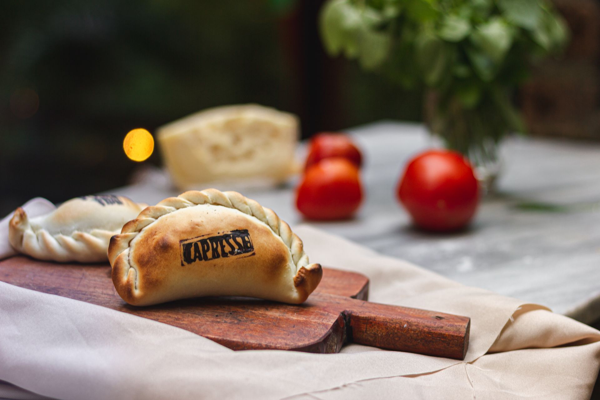 two pastries are sitting on a wooden cutting board on a table .