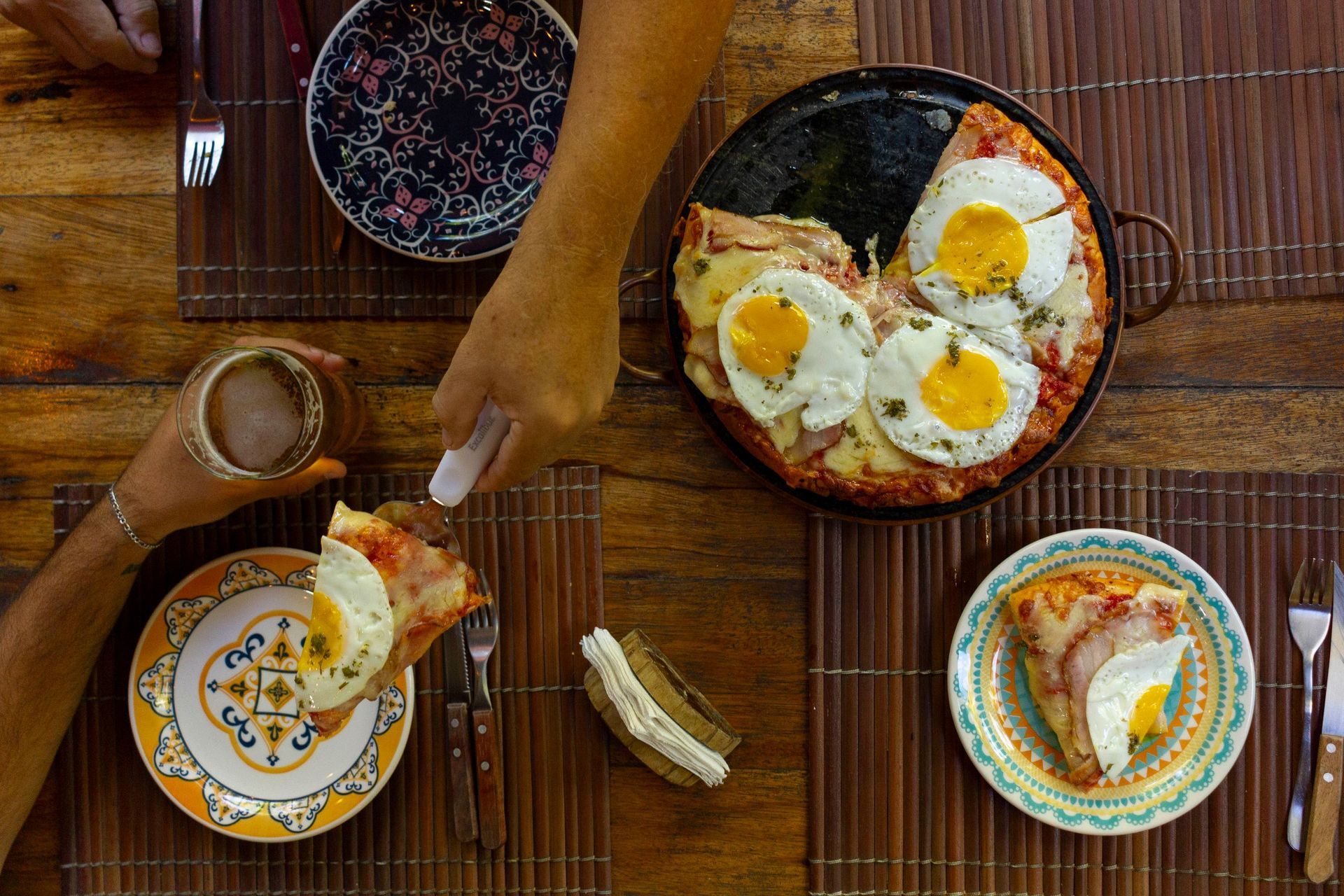 uma pessoa está cortando uma fatia de pizza com ovos