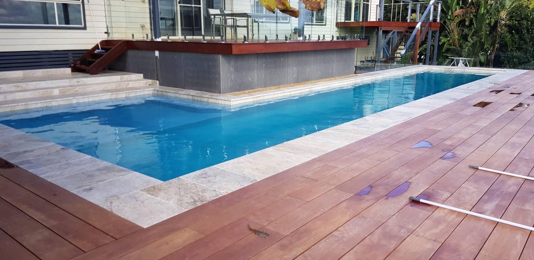A Large Swimming Pool Is Surrounded By A Wooden Deck — Ballina Pool Shop In Lennox Head, NSW