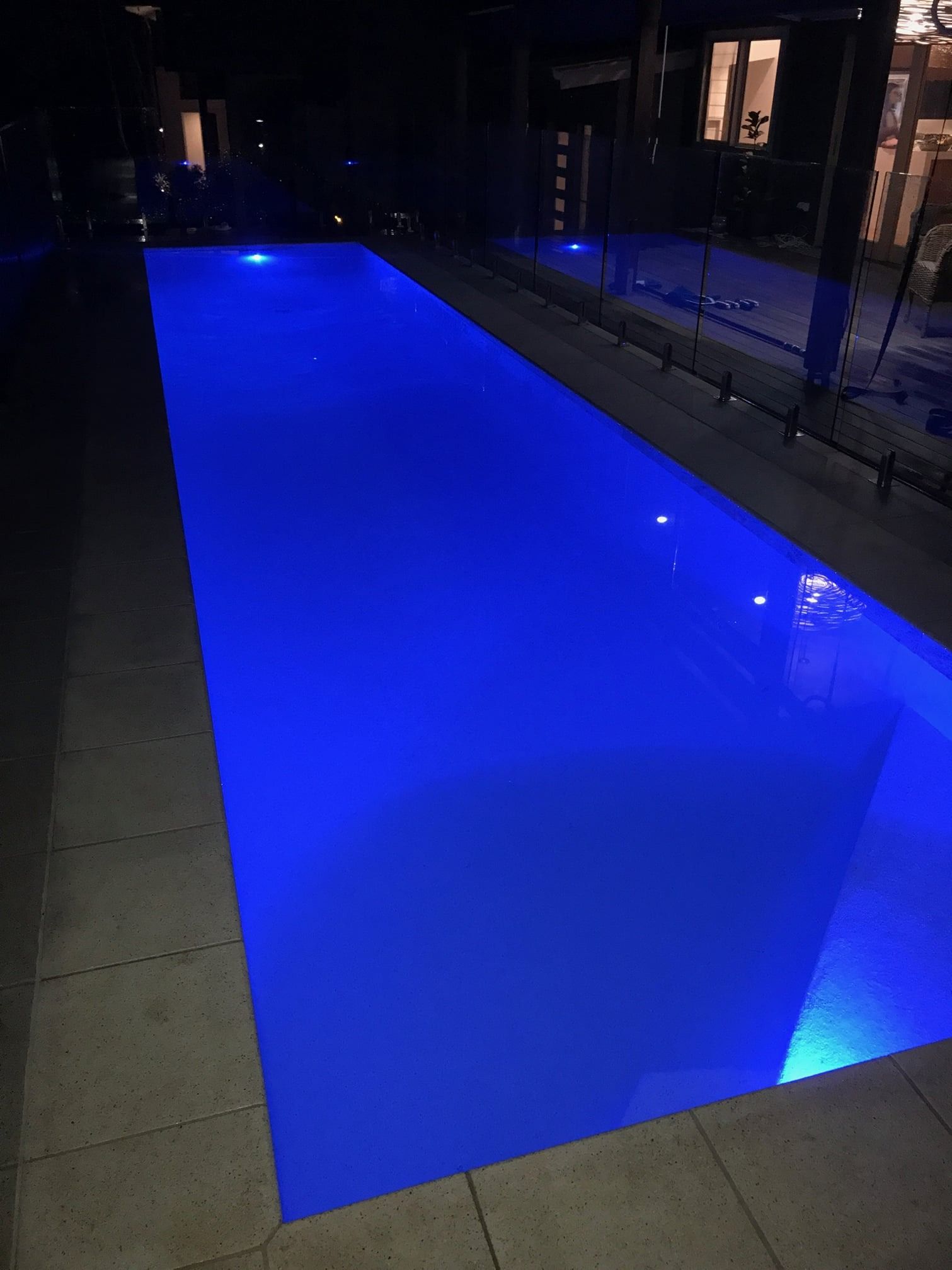 A Swimming Pool Is Lit Up With Blue Lights At Night — Ballina Pool Shop In Ballina, NSW