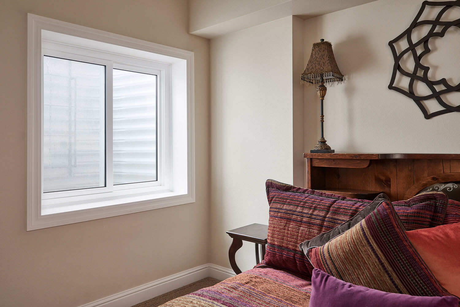 A bedroom with a bed , lamp and window.